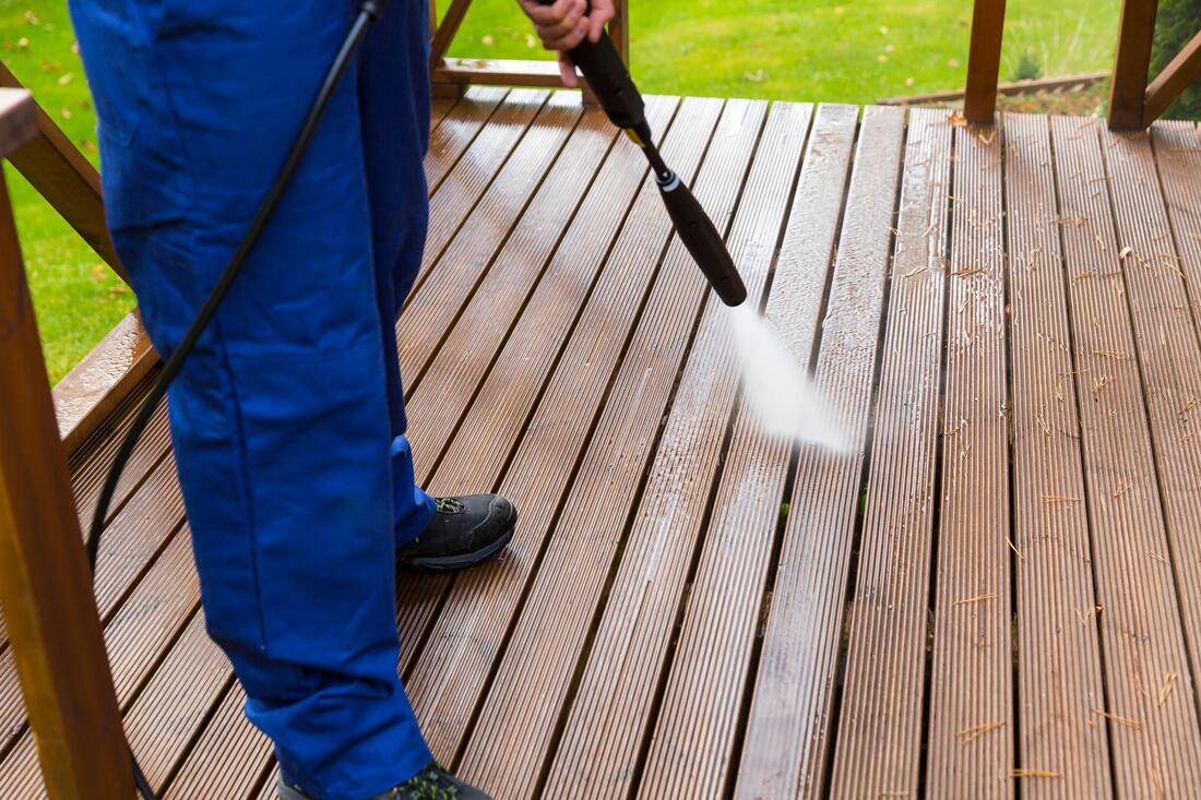 man cleaning the deck using power pressure machine